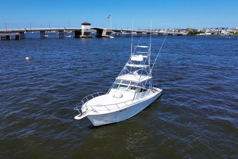 Slide: The Image of 2006 Topaz 40 Express boat on water near a bridge under clear blue sky. - 15