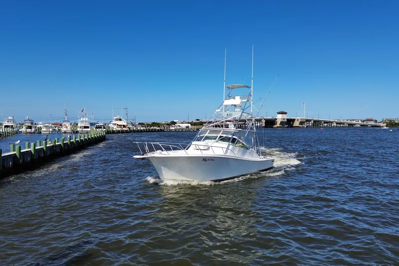Slide: The Image of 2006 Topaz 40 Express boat cruising in a marina under clear blue skies. - 17