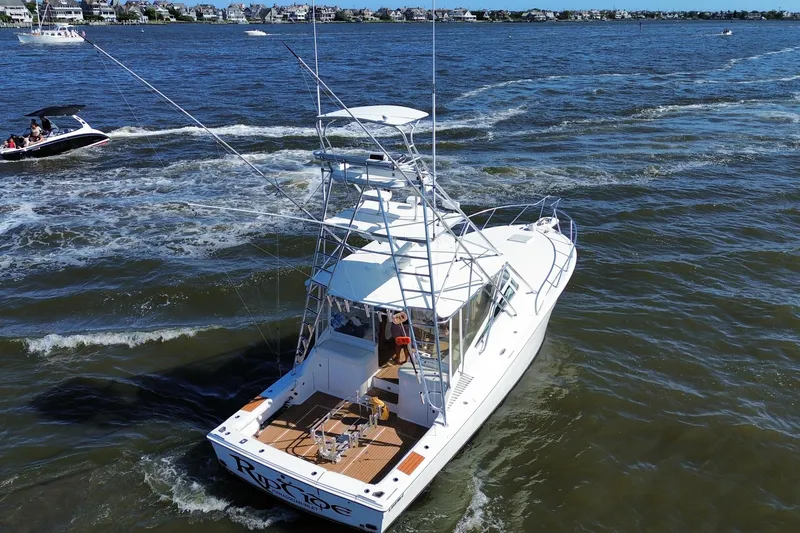 Slide: The Image of 2006 Topaz 40 Express boat cruising on a sunny day, with scenic waterfront views. - 18