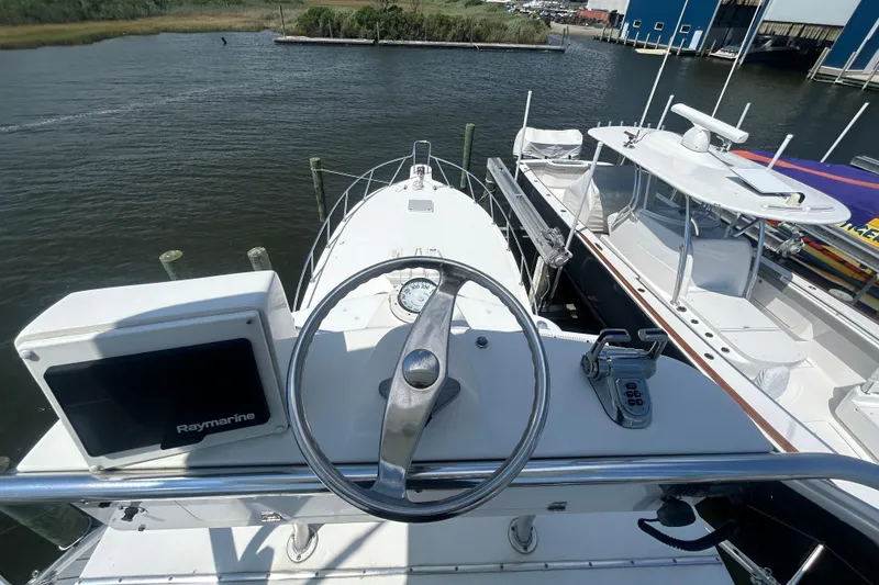 Slide: The Image of Helm of 2006 Topaz 40 Express boat with Raymarine equipment, docked near other vessels. - 26