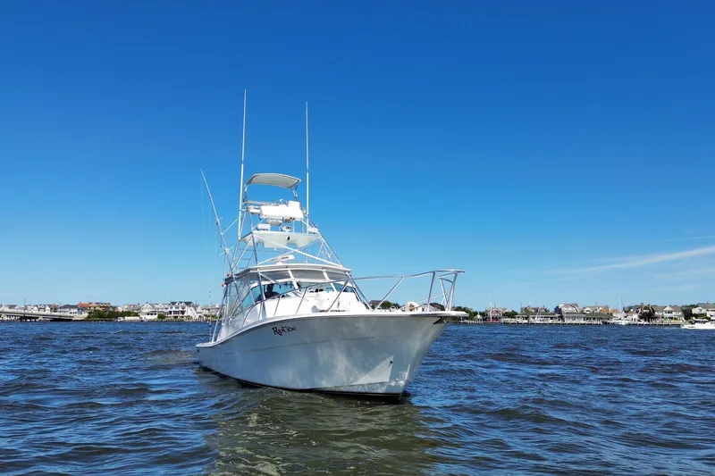 Slide: The Image of 2006 Topaz 40 Express boat on water under clear blue sky. - 3