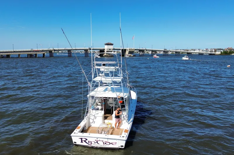 Slide: The Image of 2006 Topaz 40 Express boat on water near bridge, clear blue sky. - 8