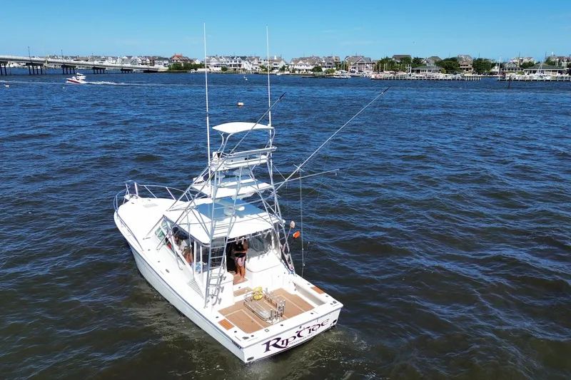 Slide: The Image of 2006 Topaz 40 Express boat on water near coastal town, clear blue sky. - 9