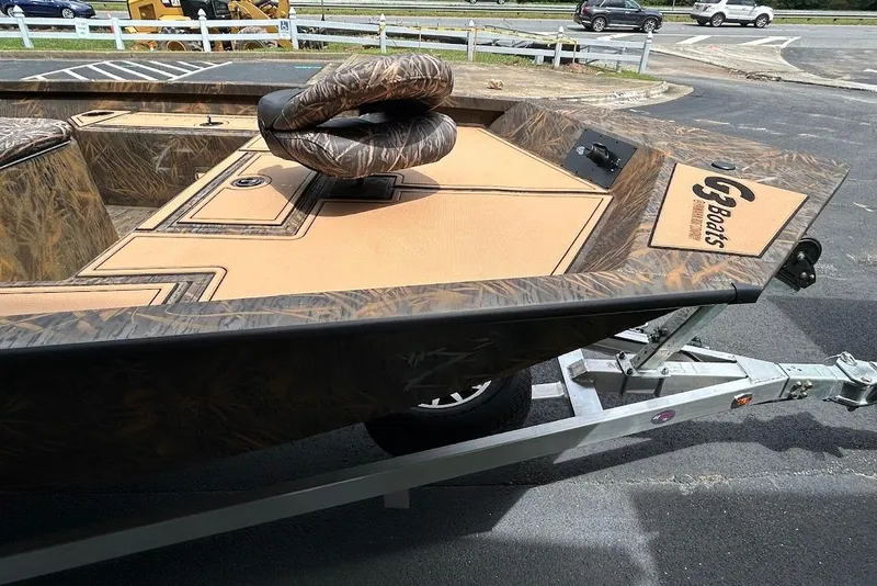 Slide: The Image of 2025 G3 Bay 19 GX Tunnel boat on trailer, featuring camo design and seating. - 5