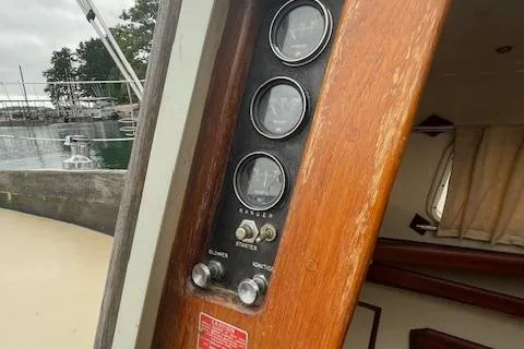 Slide: The Image of 1976 Ranger 33 sailboat interior with control panel and gauges, docked by the water. - 10