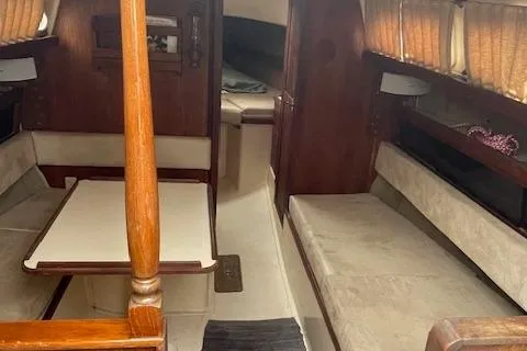 Slide: The Image of 1976 Ranger 33 sailboat interior with wood accents and beige seating. - 11