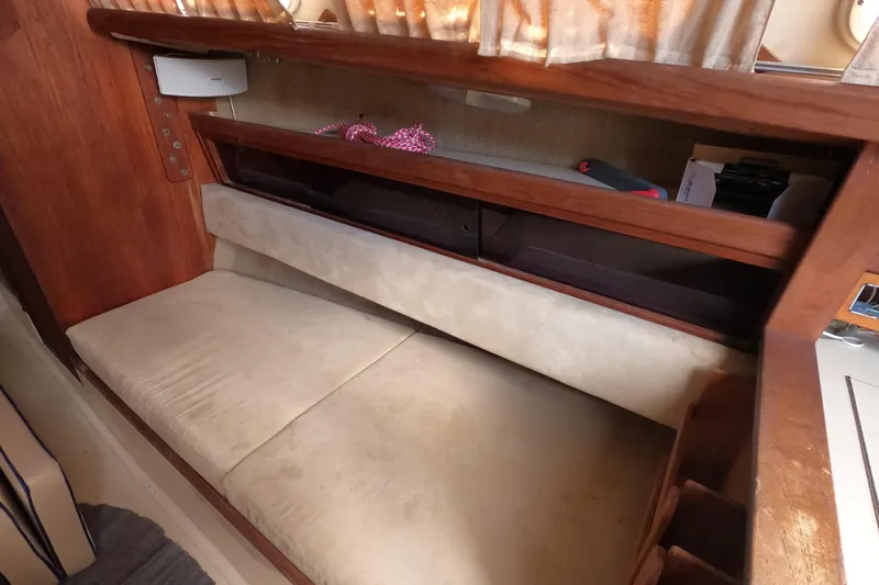 Slide: The Image of Interior of a 1976 Ranger 33 sailboat with a cushioned seating area and wooden storage. - 17