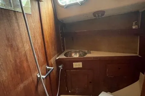 Slide: The Image of 1976 Ranger 33 boat interior with wooden cabinetry and stainless steel sink. - 24