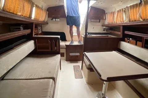 Slide: The Image of Interior of a 1976 Ranger 33 sailboat with cozy seating and wooden accents. - 27