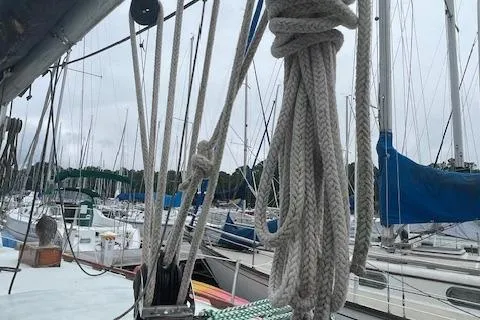 Slide: The Image of 1976 Ranger 33 sailboat with ropes, docked among other boats in a marina. - 9