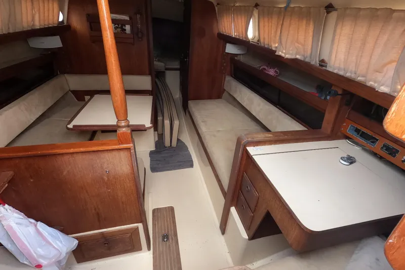 Slide: The Image of Interior of a 1976 Ranger 33 sailboat with wood furnishings and beige seating. - 12