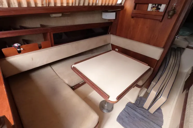 Slide: The Image of 1976 Ranger 33 sailboat interior with cozy dining area and wooden accents. - 18