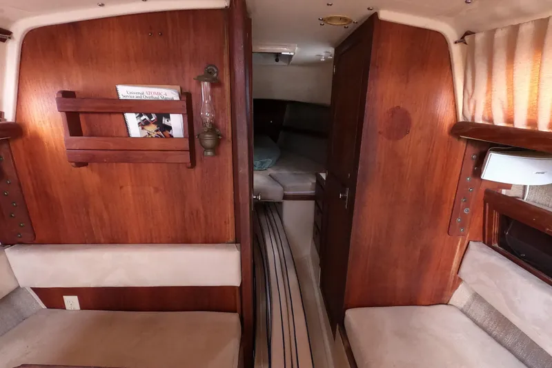 Slide: The Image of Interior of a 1976 Ranger 33 sailboat with wooden paneling and cozy seating. - 19