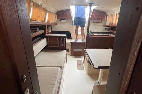 Slide: The Image of Interior of a 1976 Ranger 33 sailboat with cozy seating and wooden cabinetry. - 26