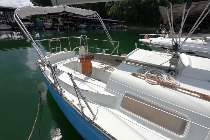 Slide: The Image of 1976 Ranger 33 sailboat docked in a marina, featuring a clean deck and coiled ropes. - 3