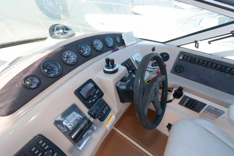 Slide: The Image of 2005 Carver 360 Mariner helm with steering wheel, gauges, and control panel. - 11