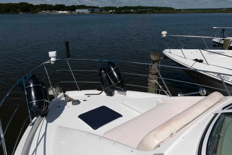 Slide: The Image of 2005 Carver 360 Mariner yacht docked by serene waters, featuring spacious deck seating. - 4