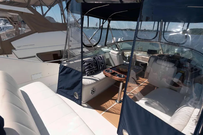 Slide: The Image of 2005 Carver 360 Mariner yacht interior with seating and helm, docked by the water. - 6