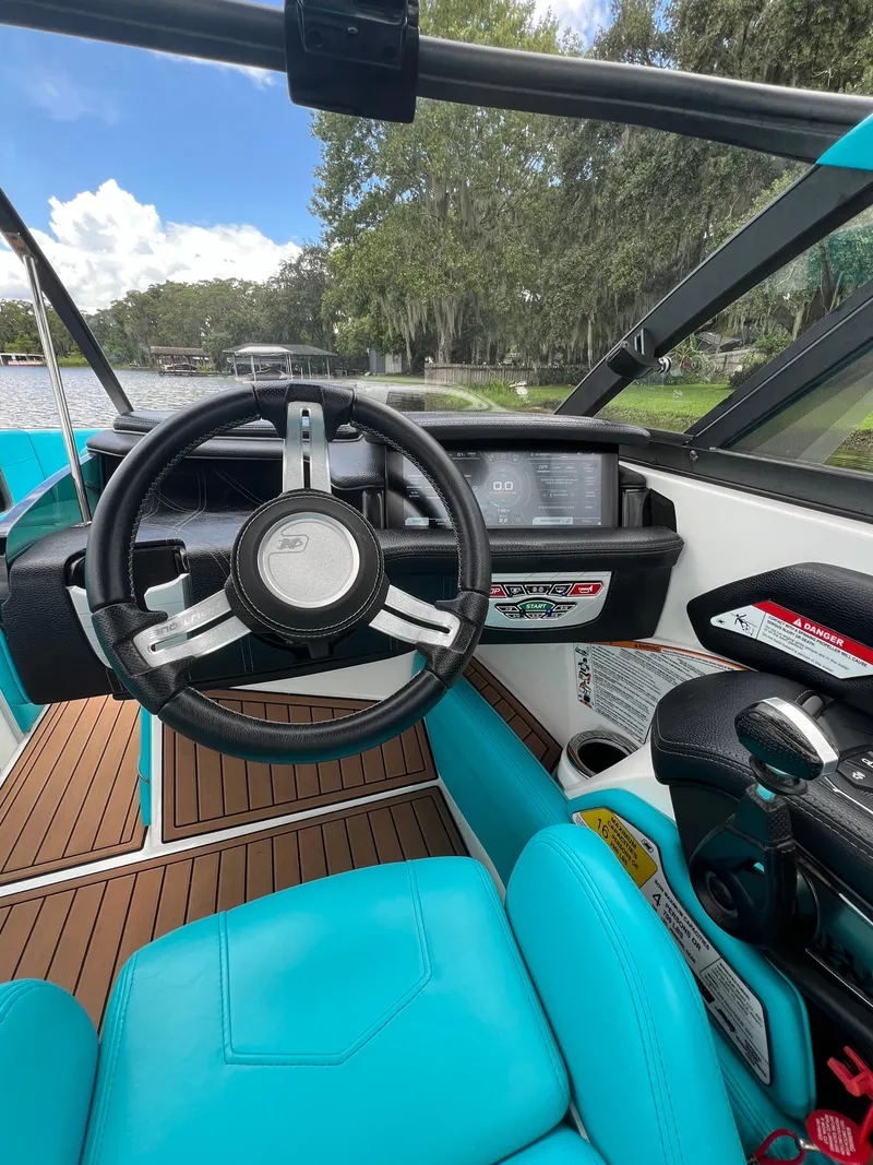 Slide: The Image of 2018 Nautique Super Air G23 boat interior with turquoise seating and sleek steering wheel. - 5