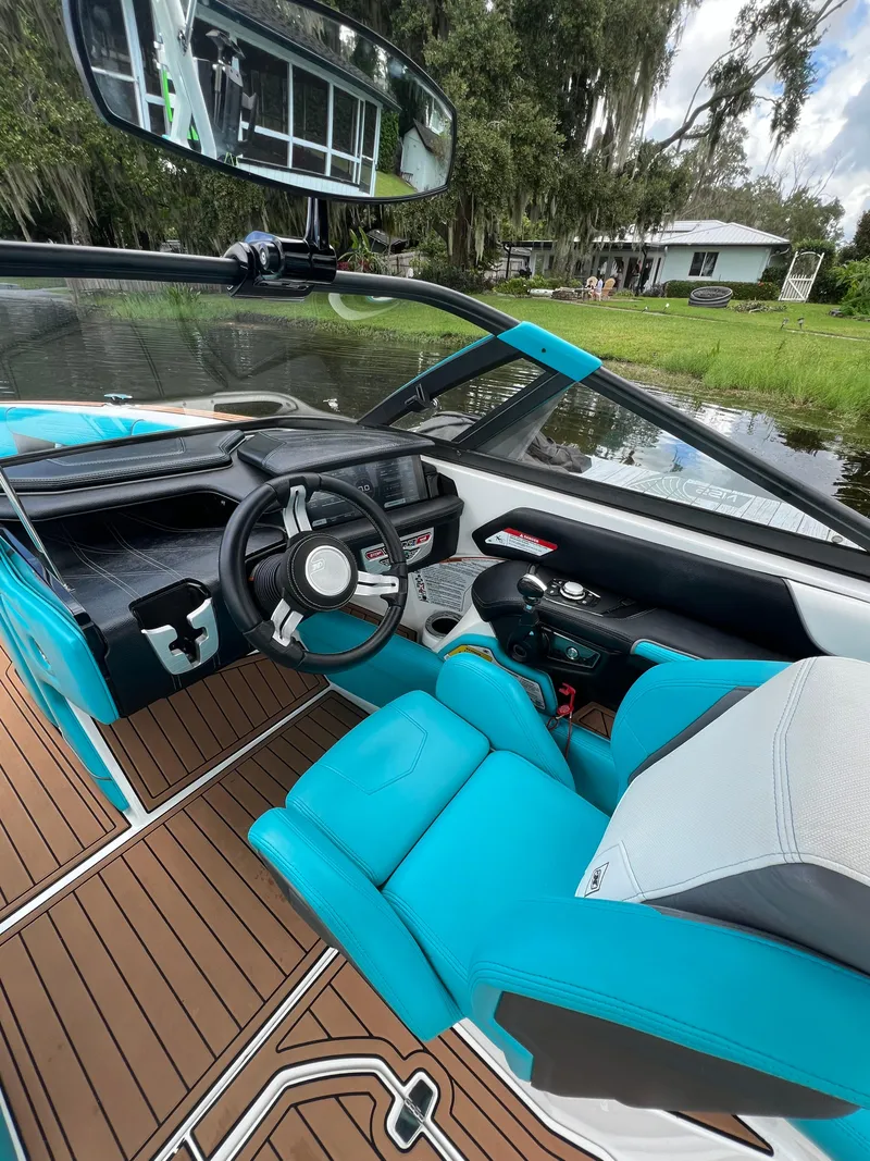 Slide: The Image of 2018 Nautique Super Air G23 interior with turquoise seats and wooden flooring. - 6