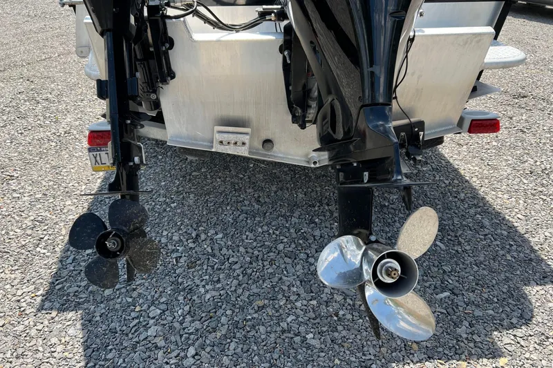 Slide: The Image of 2021 Hewescraft 220 Ocean Pro ET boat with dual outboard motors on gravel. - 13