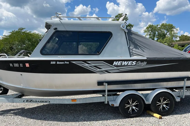 Slide: The Image of 2021 Hewescraft 220 Ocean Pro ET boat on trailer under a cloudy sky. - 7