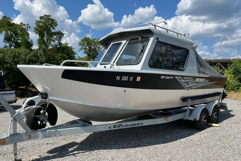 Slide: The Image of 2021 Hewescraft 220 Ocean Pro ET boat on trailer, parked outdoors under a blue sky. - 8