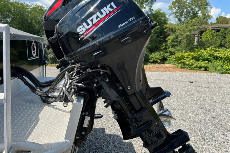 Slide: The Image of Suzuki outboard motor on 2021 Hewescraft 220 Ocean Pro ET, parked on gravel. - 9