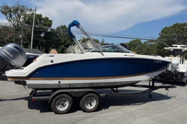 Slide: The Image of 2018 Four Winns HD220 OB boat on trailer, blue and white design, parked outdoors. - 4