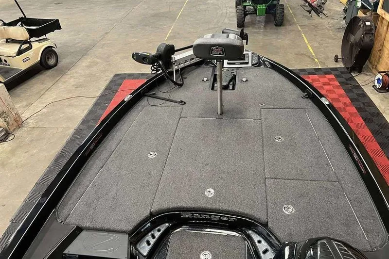 Slide: The Image of 2018 Ranger Z520C boat interior with gray carpet and seating, in a garage setting. - 6