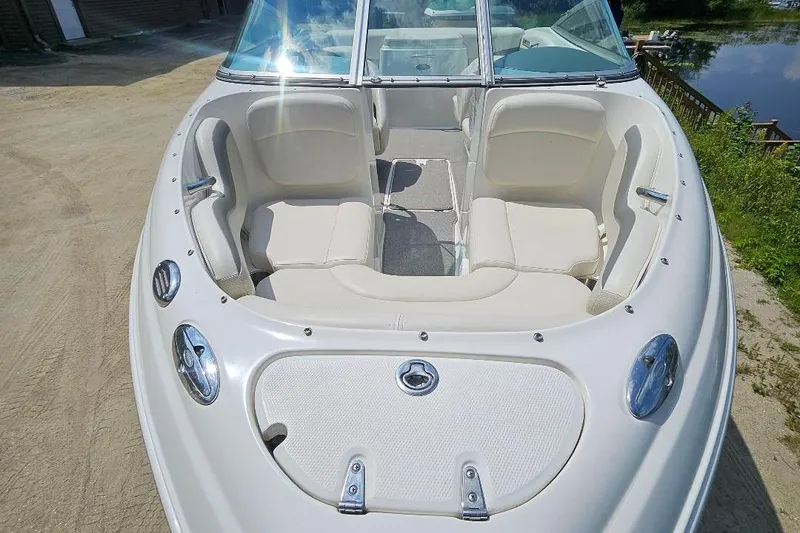 Slide: The Image of 2006 Chaparral 190 SSi boat with white seating and sleek design, docked near water. - 5