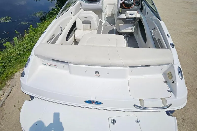 Slide: The Image of 2006 Chaparral 190 SSi boat interior with white seating and steering wheel, near water. - 6