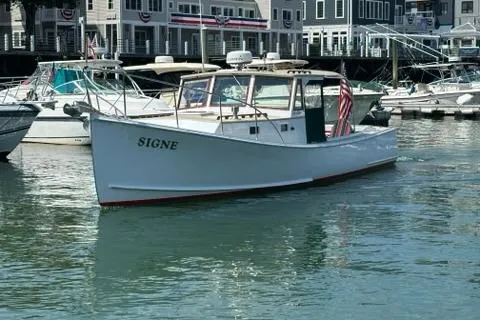 Slide: The Image of 1987 Holland 32 boat named "SIGNE" docked in a marina with American flag. - 0