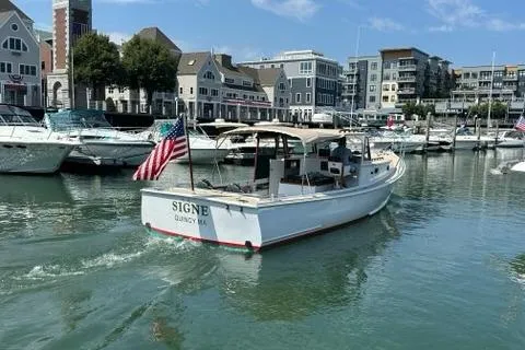 Slide: The Image of 1987 Holland 32 boat named "SIGNE" in a marina, flying an American flag. - 10