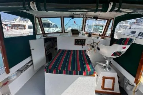 Slide: The Image of Interior of a 1987 Holland 32 boat with striped seating and steering wheel. - 13