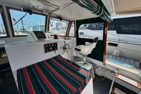 Slide: The Image of Interior of a 1987 Holland 32 boat with striped seating and navigational equipment. - 14