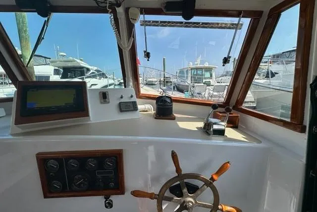 Slide: The Image of 1987 Holland 32 boat cockpit with navigation system and marina view. - 16