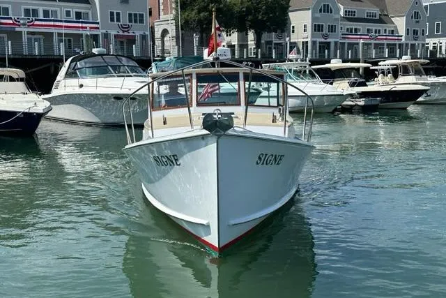 Slide: The Image of 1987 Holland 32 boat named "SIGNE" docked in a marina with other vessels. - 2