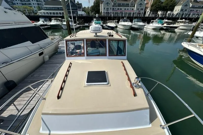 Slide: The Image of 1987 Holland 32 boat deck with wooden handrail, docked in a marina with yachts. - 28