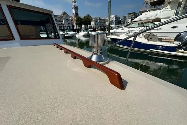 Slide: The Image of 1987 Holland 32 boat deck with wooden railing, docked near other vessels. - 29