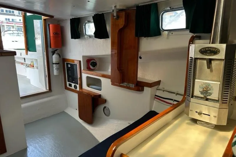 Slide: The Image of Cozy cabin interior of 1987 Holland 32 boat with cushioned seating and wooden accents. - 36