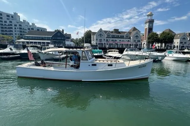 Slide: The Image of 1987 Holland 32 boat docked in scenic marina with historic buildings in background. - 4