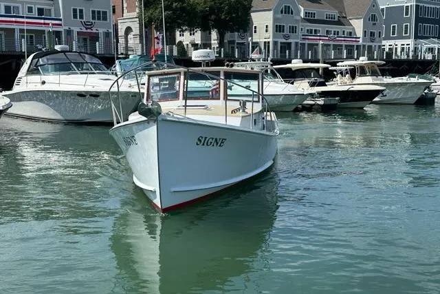Slide: The Image of 1987 Holland 32 boat named "Signe" docked in a marina with other vessels. - 5