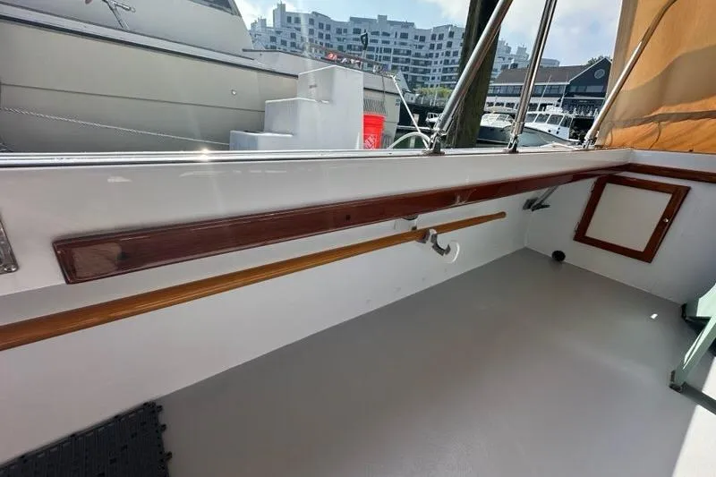 Slide: The Image of 1987 Holland 32 boat deck with marina view, featuring docked yachts and waterfront buildings. - 58