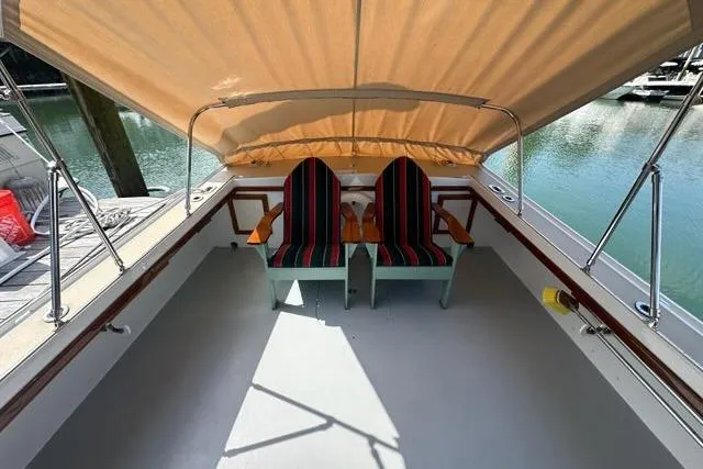 Slide: The Image of Two striped chairs on a 1987 Holland 32 boat with an American flag, docked at a marina. - 67