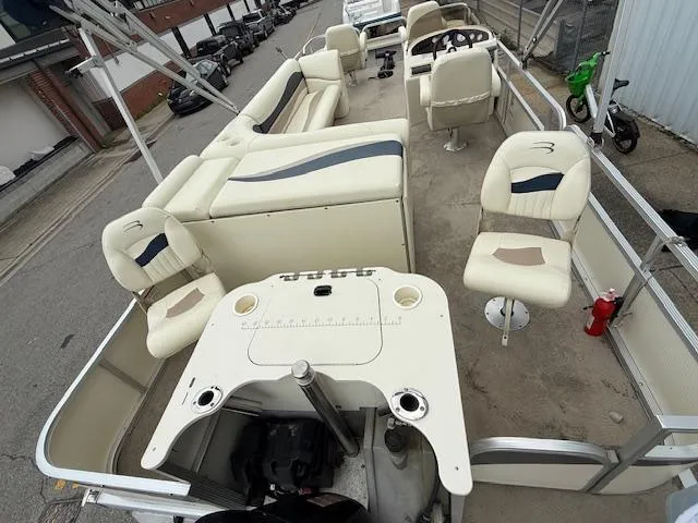 Slide: The Image of 2008 Bennington 2277FSi pontoon boat with beige seating and helm, docked in an urban area. - 20