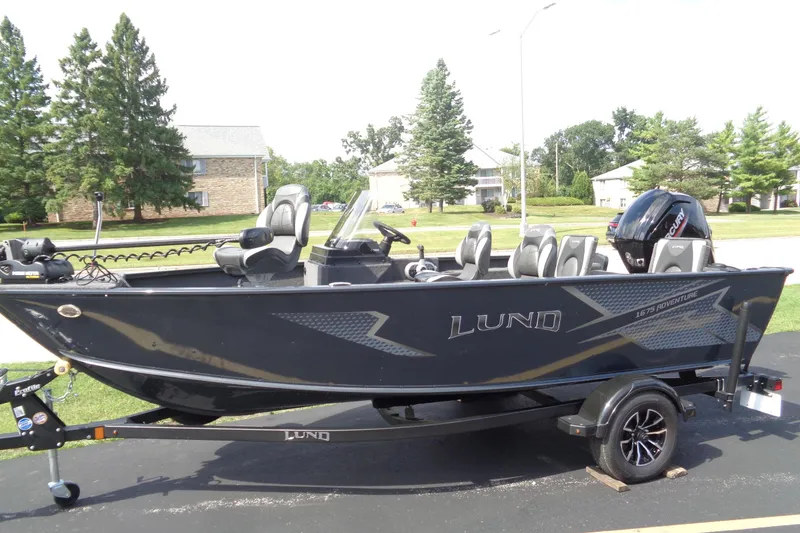 Slide: The Image of 2025 Lund 1675 Adventure SS boat on trailer, parked outdoors. - 0