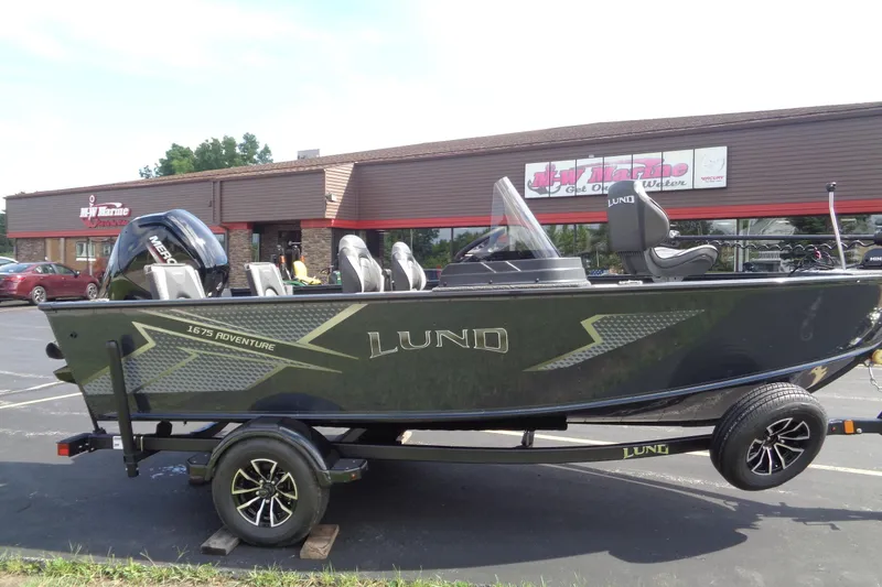 Slide: The Image of 2025 Lund 1675 Adventure SS boat on trailer outside dealership. - 1