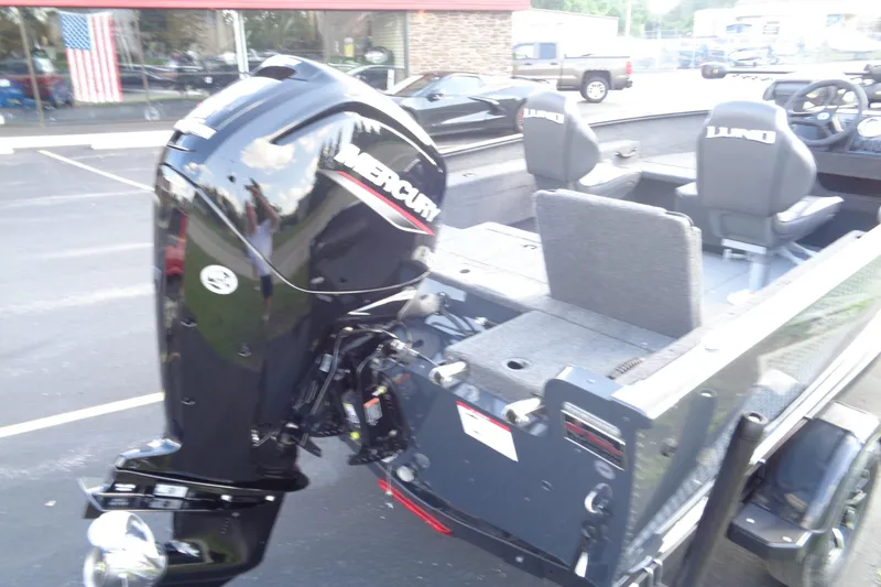 Slide: The Image of 2025 Lund 1675 Adventure SS boat with Mercury outboard motor, parked outdoors. - 16