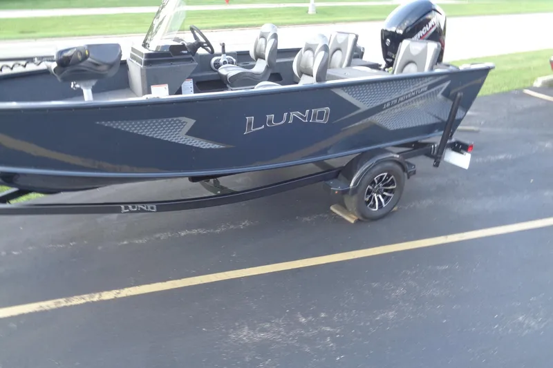 Slide: The Image of 2025 Lund 1675 Adventure SS boat on trailer, parked on asphalt. - 6